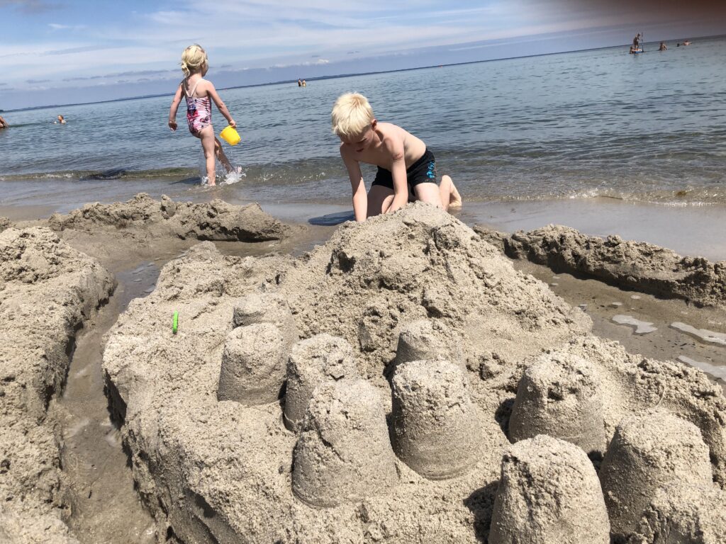Børnene bygger sandslot ved stranden